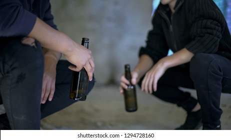 Drunkards holding beer bottles resting in abandoned house, social issue, problem