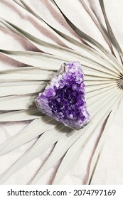druse raw purple amethyst crystal on palm leaf, magic rock for ritual, witchcraft, spiritual practice, meditation.esoteric life balance concept. 