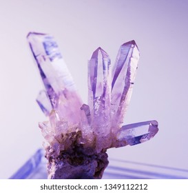 Druze of several purple crystals of natural gemstone amethyst from Vera Cruz mine on violet background