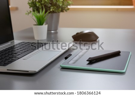 Drwaing tablet and laptop on a gray table