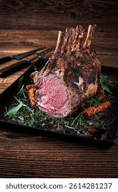 dry aged bone-in back rack of veal  loin roasted with herbs and spices served on a black board