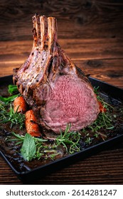 dry aged bone-in back rack of veal  loin roasted with herbs and spices served on a black board
