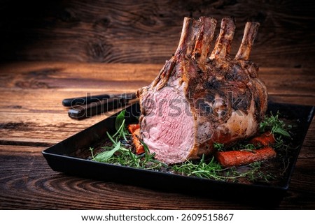 dry aged bone-in back rack of veal  loin roasted with herbs and spices served on a black board