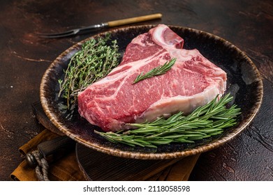 Dry Aged Raw Porterhouse Beef Meat Steak, Fresh T Bone On Rustic Plate With Spices. Dark Background. Top View