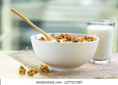 Dry breakfast cereals. Crunchy honey granola bowl with flax seeds, cranberries and coconut and a glass of milk on a table. Healthy and fiber food. Breakfast time  - Powered by Shutterstock