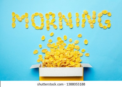 Dry breakfast cornflakes. Morning and placer flakes from box on blue background.