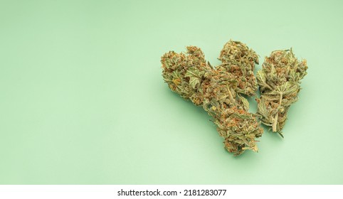 Dry Cannabis Buds Flowers On A Green Background. Top View Of Medical Marijuana Flower. ​Concept Of Marijuana Plantation For Medical And Business
