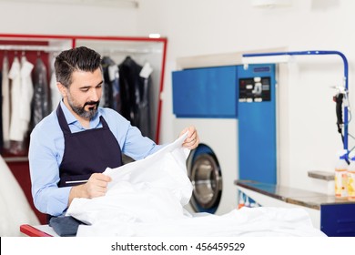 Dry Cleaner Working In Shop.