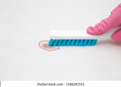 Dry Cleaner's Employee Hand In Rubber Protective Glove Removing Fresh Or Old Blood Stain From White Mattress With Brush. Commercial Cleaning Company. Close Up. Front View.