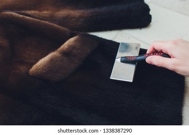 Dry Cleaning Business Concept. Woman Working With Fur Coat And Brush.