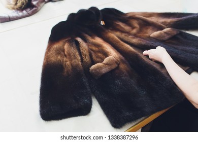 Dry Cleaning Business Concept. Woman Working With Fur Coat And Brush.