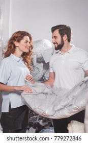 Dry Cleaning Workers With Jacket In Bag At Warehouse