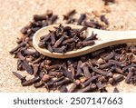 Dry clove spice on a wooden spoon close up. Spicy spice of cloves.  Dry spice cloves.