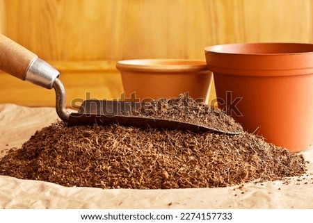 Dry coconut fibre substrate made eco-friendly and cheap from coco coir bricks, ready to use as grow or potting soil, with a trowel and empty pots.