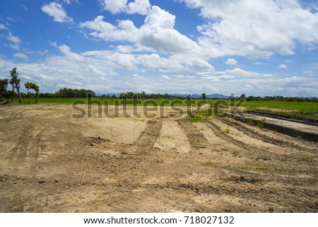 Dry crack red and sticky soil from swamp dredging or digging, reclamation land area prepare for house construction in rural area with wide blue sky and fresh air, North of Thailand