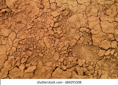 Dry cracked dirt texture background. Red clay desert. Illustration for news about soil erosion