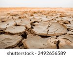 Dry and cracked land, Dry and cracked red brown soil ground during drought. Ground cracks top view. Effects of climate change such as desertification and droughts.