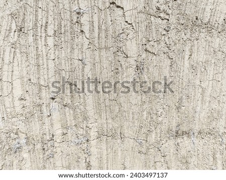 Dry cracked plaster texture with vertical striations and random crack patterns