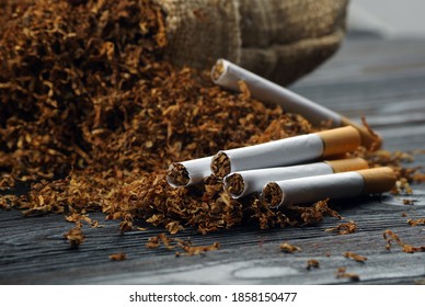 Dry Cut Tobacco Leaf And Cigarettes On A Wooden Table. Close Up