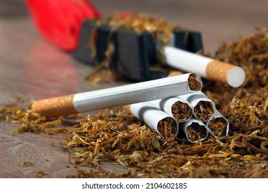 Dry Cut Tobacco Leaf, Cigarettes And Cigarette Machine On Wooden Table. Handmade Cigarettes