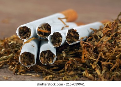 Dry Cut Tobacco Leaf And Cigarettes On A Wooden Table. Close Up