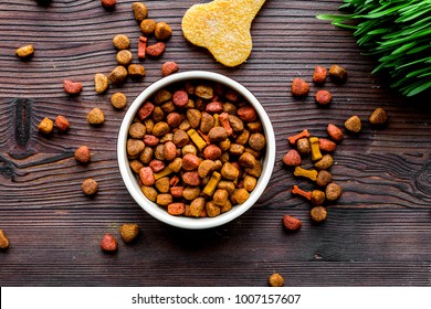 Dry Dog Food In Bowl On Wooden Background Top View