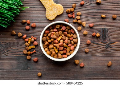 Dry Dog Food In Bowl On Wooden Background Top View