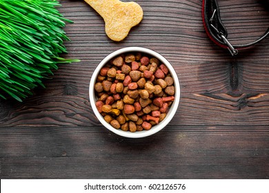 Dry Dog Food In Bowl On Wooden Background Top View