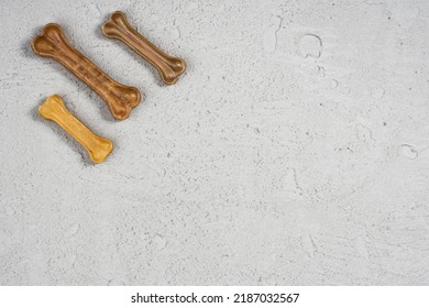 Dry Dog Pet Food On Gray Concrete Background Top View. Pet Feeding And Care Concept Background With Copy Space. Photograph Taken From Above.