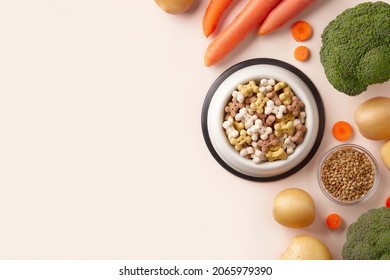 Dry Dog Vegan Vegetarian Food Concept. Raw Vegetables And Green Near Bowl With Pet Feed On Beige Background