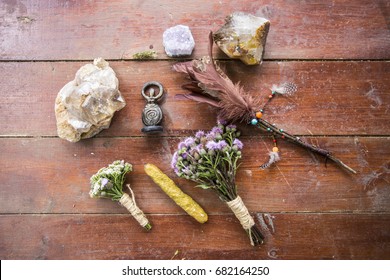 Dry flowers, a thistle, a staff of feathers, a crystal of quartzite and candles made from natural wax, witchcraft, spells, magic, Wicca, the goddess