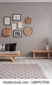 Dry Flowers In White Vase On Small Wooden Table Behind Comfortable Futon Sofa With Pillows