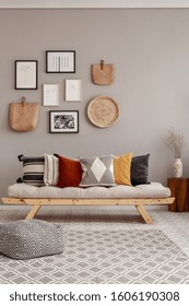 Dry Flowers In White Vase On Small Wooden Table Behind Comfortable Futon Sofa With Pillows