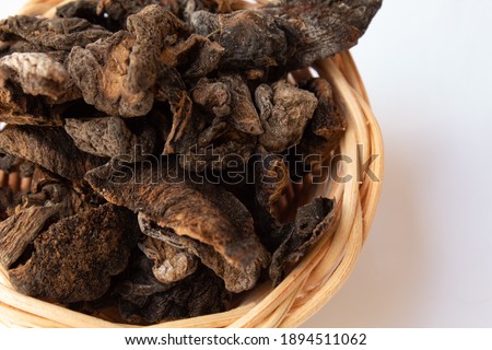 Dry funghi mushroom in small wicker basket, isolated on white background