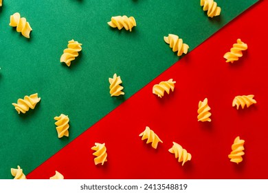 Dry fusilli pasta pattern on red and green colored backdrop  italian pasta concept - Powered by Shutterstock