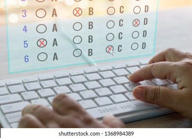 Dry hand of adult student using white keyboard on table to do test examination with multiple choice questions on virtual screen at home. Education futuristic technology and Lifelong learning concept. - Shutterstock ID 1368984389