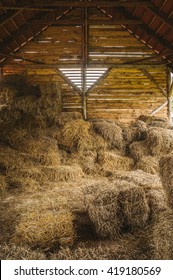 Dry Hay Stacks In Rural Wooden Barn Interior