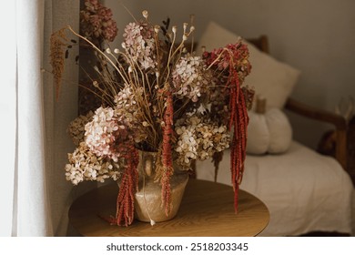 Dry hydrangea, poppy and amaranth in stylish vase close up. Fall decor in modern living room. Thanksgiving and Halloween. Autumn floral arrangement - Powered by Shutterstock