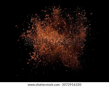 Dry instant coffee explosion on black background