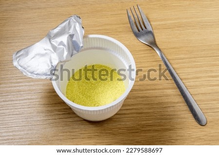 dry instant mashed potatoes in a plastic cup on the table