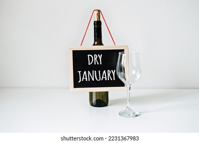 Dry January. Alcohol-free challenge, Health campaign urging people to abstain from alcohol for the January month. Bottle of wine, glass and sign with text Dry January