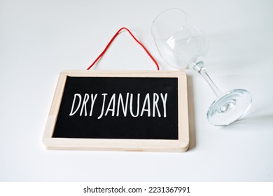 Dry January. Alcohol-free challenge, Health campaign urging people to abstain from alcohol for the January month. Bottle of wine, glass and sign with text Dry January - Powered by Shutterstock