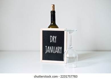 Dry January. Alcohol-free challenge, Health campaign urging people to abstain from alcohol for the January month. Bottle of wine, glass and sign with text Dry January - Shutterstock ID 2231757783