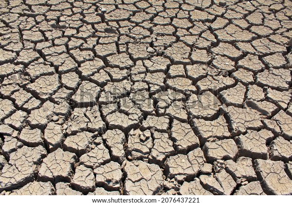 A dry, lifeless, barren clay land cracked in\
the African desert during global warming and climate change. A hot\
surface during drought is destroyed, eroded and textured. Copy\
space, background.