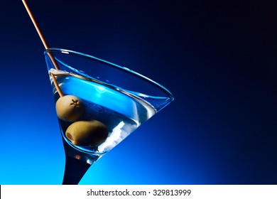 dry martini with olives ,focus on a berry