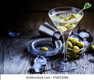 Dry martini, vermouth with green olives, black background, selective focus
