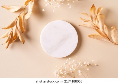 Dry natural grass, leaves and flowers frame with white marble podium, beauty and fashion concept mock up on beige background flat lay, top view, copy space - Shutterstock ID 2174188055