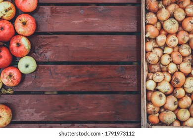 A Lot Of Dry Onions, Bunch Of Damaged Red Apples In Full Shabby Wooden Plank Container Box On Brown Table. Summer, Autumn Season Lean Poor, Bad Harvest. Countryside Farm. Coronavirus Food Crisis.