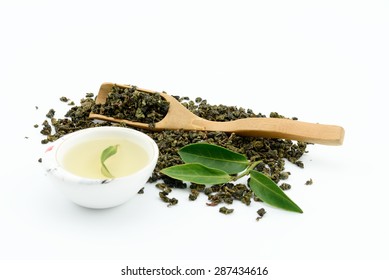 Dry Oolong Tea Leaf From China And Tea In Traditional Cup With Bamboo Scoop On White Background.