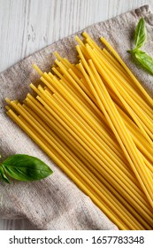 Dry Organic Bucatini Pasta On Cloth, Overhead View. From Above, Flat Lay, Top View. Close-up.